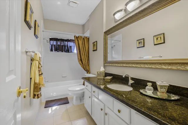 a view of a hallway with wooden floor and a bathroom