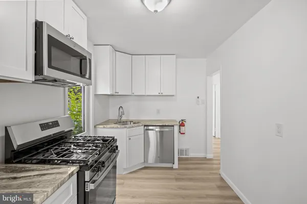 a kitchen with stainless steel appliances granite countertop a stove and a microwave