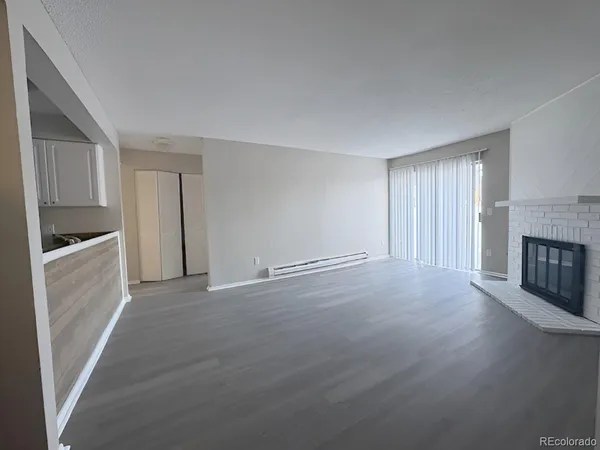 a view of an empty room with a fireplace and a window