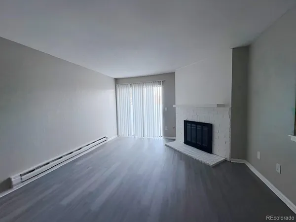 an empty room with wooden floor and fireplace