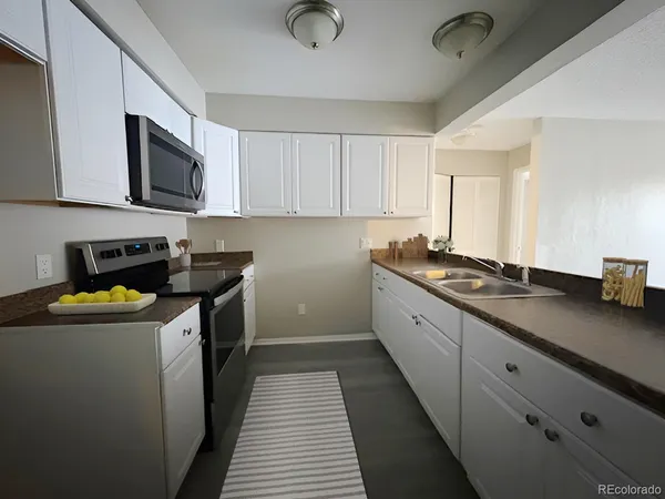 a kitchen with stainless steel appliances granite countertop a sink a stove top oven a counter space and cabinets