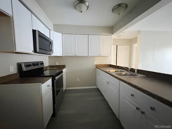 a spacious bedroom with a bed and a chandelier
