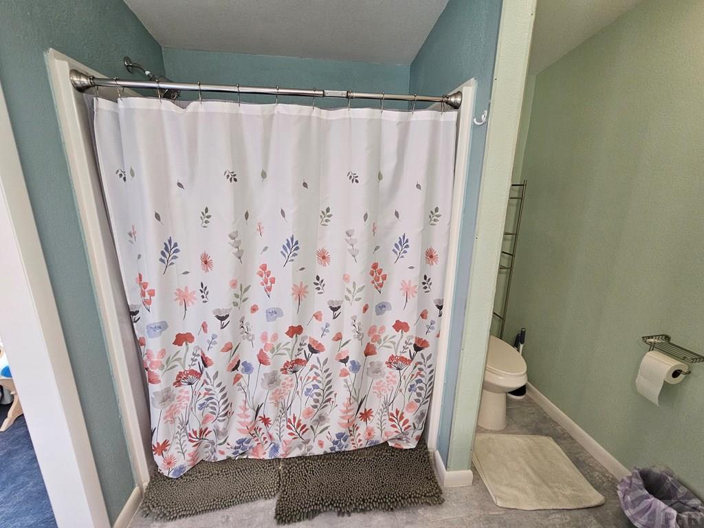 1302 Rittgers Street Eads, CO 81036 - Photo 12 of 29 a bathroom with a toilet and shower curtain