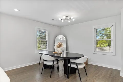 a view of a dining room with furniture a chandelier and wooden floor