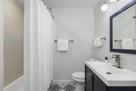 a bedroom with a bed and a computer on a table