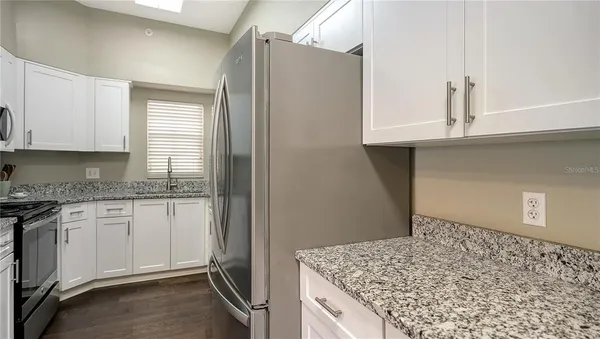 a kitchen with granite countertop cabinets stainless steel appliances and a counter space