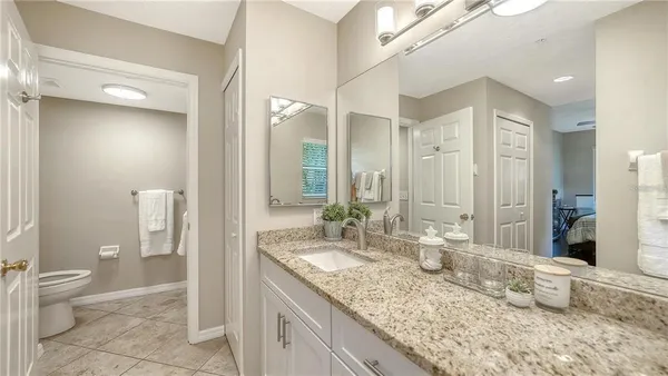 a bathroom with a granite countertop sink and a mirror
