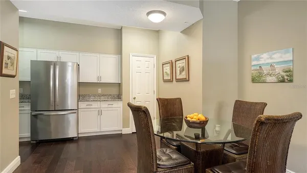 a kitchen with stainless steel appliances granite countertop a refrigerator and a dining table