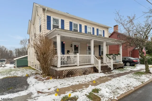 a front view of a house with a yard covered in snow