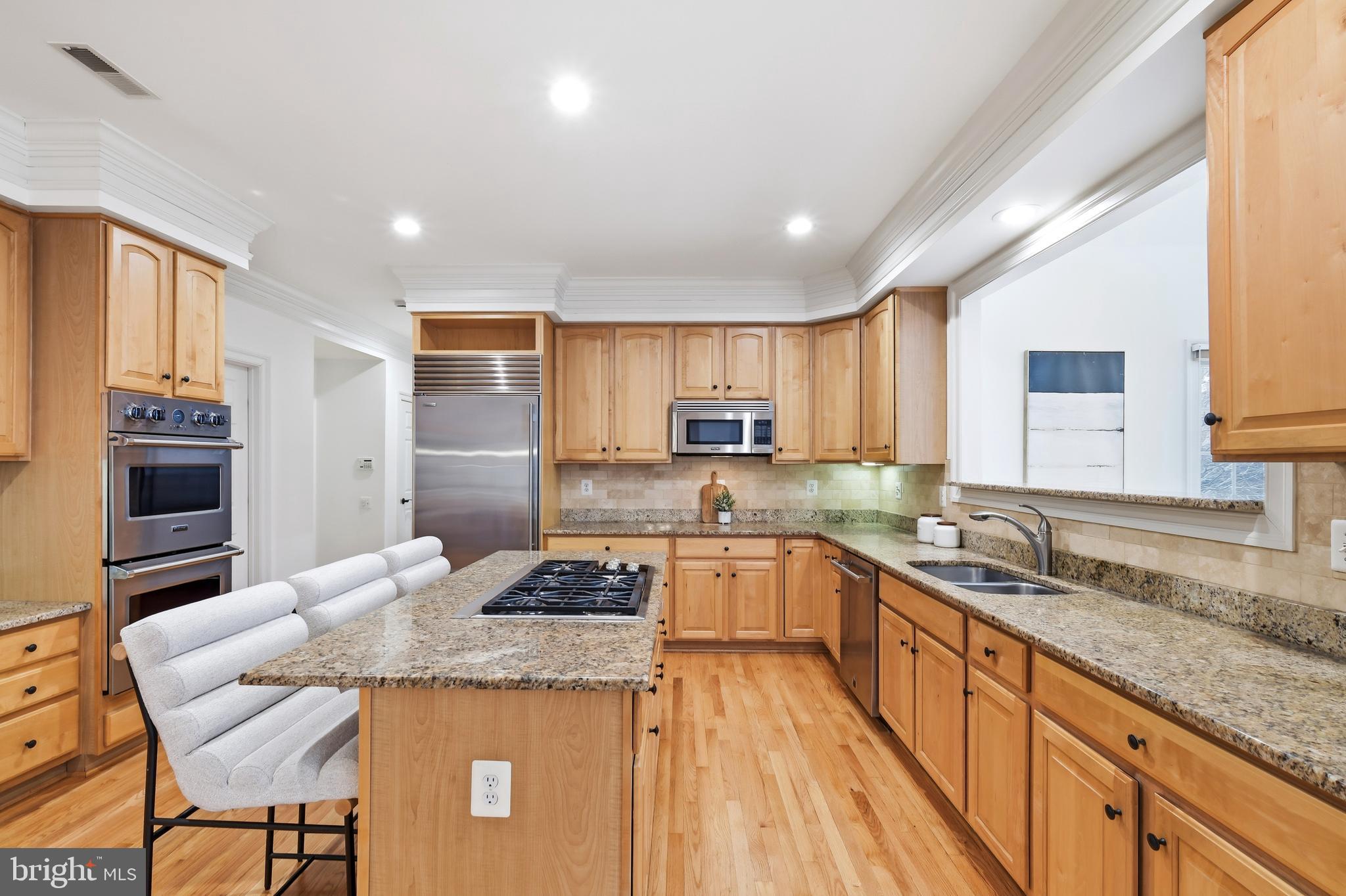 10405 Sandringham Court Potomac, MD 20854 - Photo 24 of 85 a kitchen with granite countertop kitchen island stainless steel appliances a sink stove and refrigerator