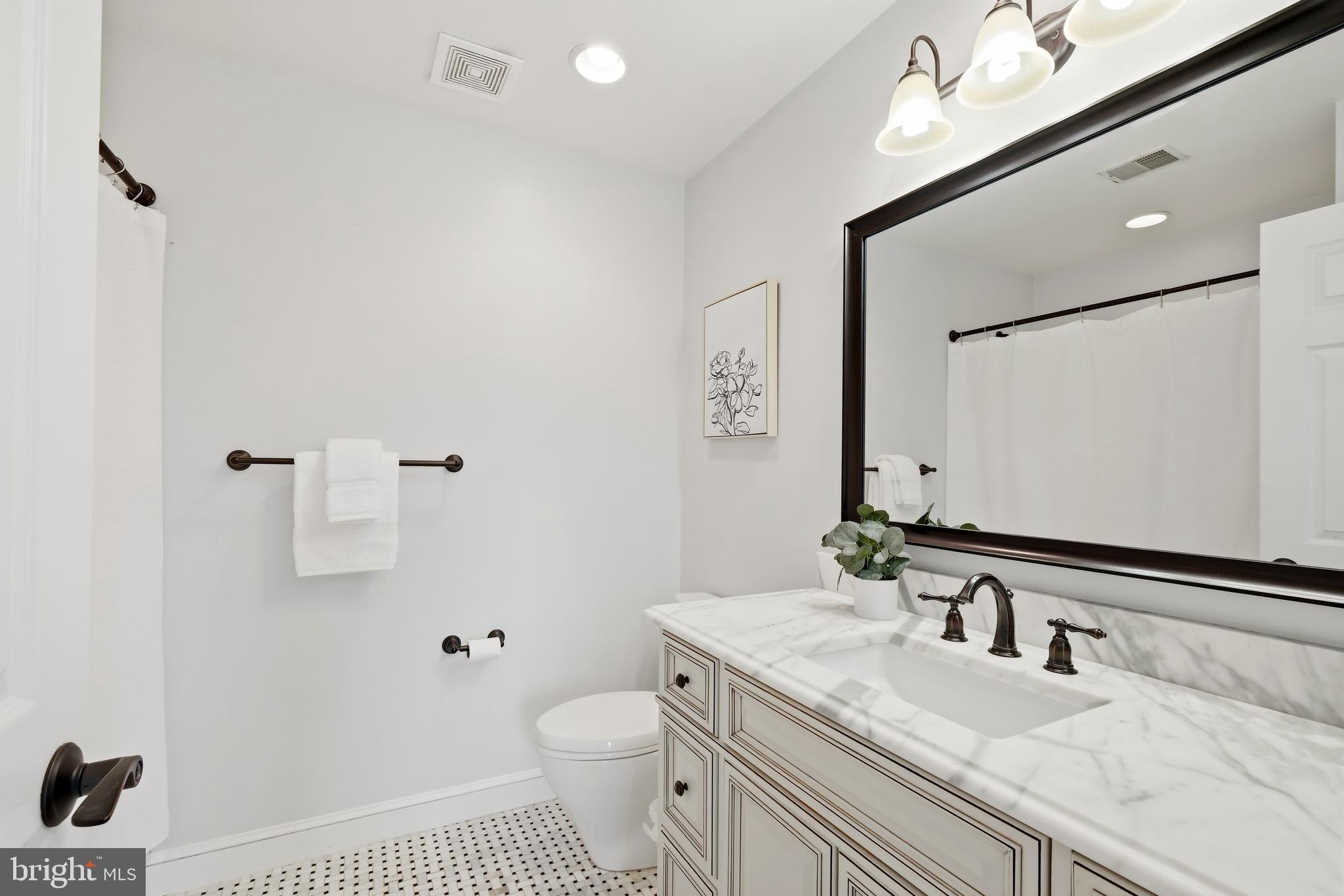10405 Sandringham Court Potomac, MD 20854 - Photo 51 of 85 a bathroom with a granite countertop sink a toilet a mirror and shower