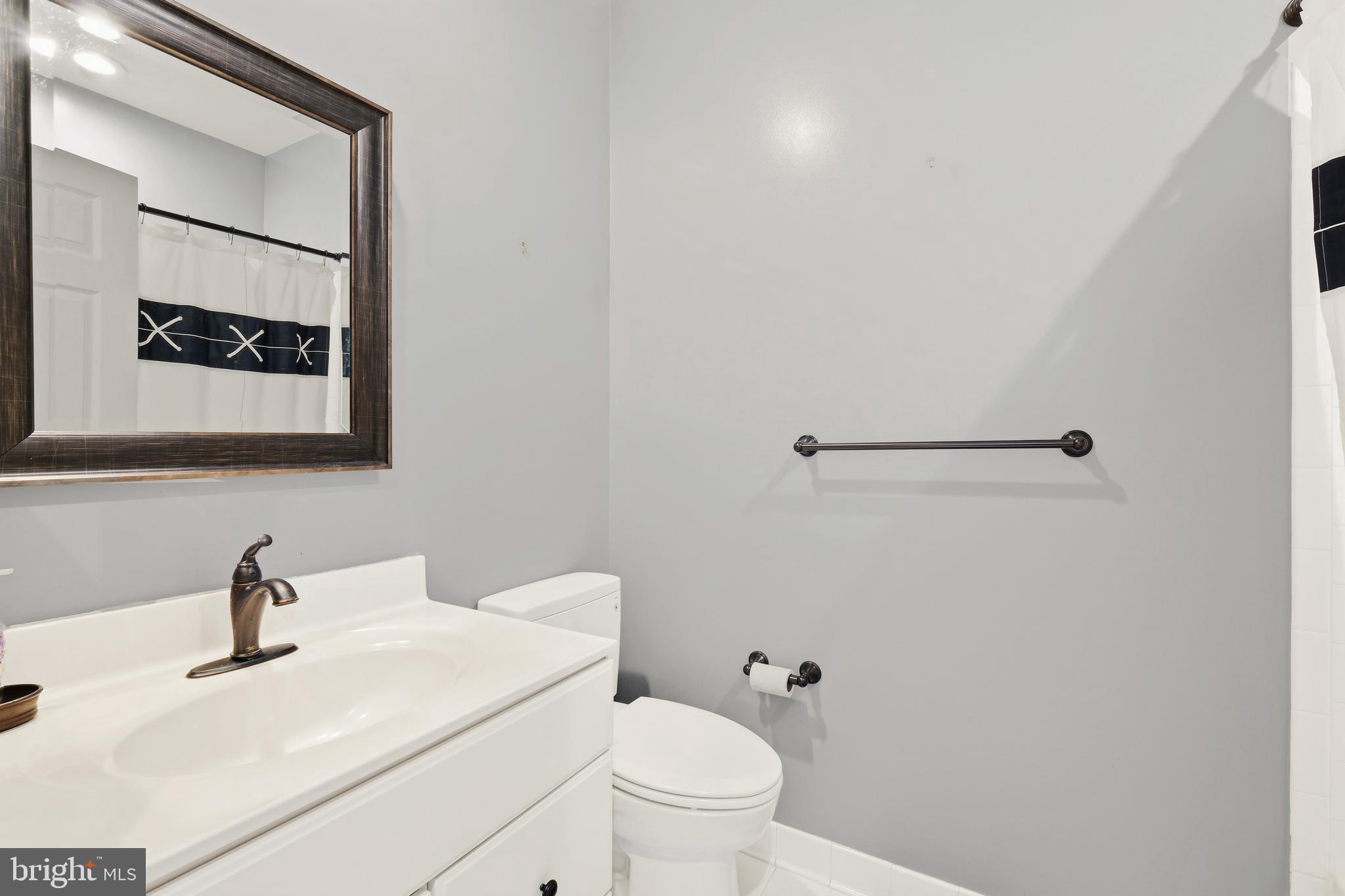 10405 Sandringham Court Potomac, MD 20854 - Photo 64 of 85 a bathroom with a toilet sink vanity and mirror