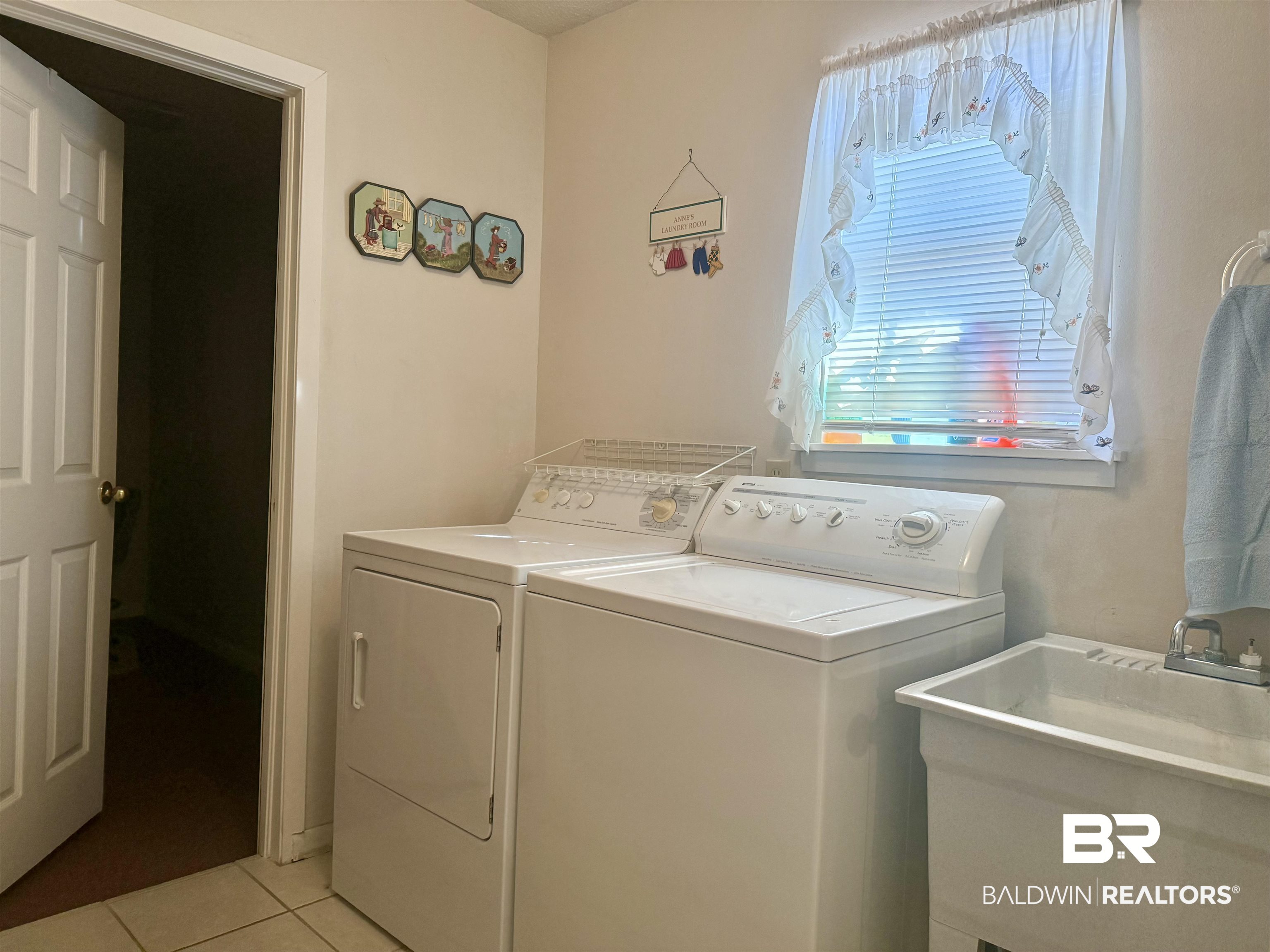 215 Young Street Brewton, AL 36426 - Photo 17 of 25 Laundry area with light tile patterned floors and washing machine and clothes dryer