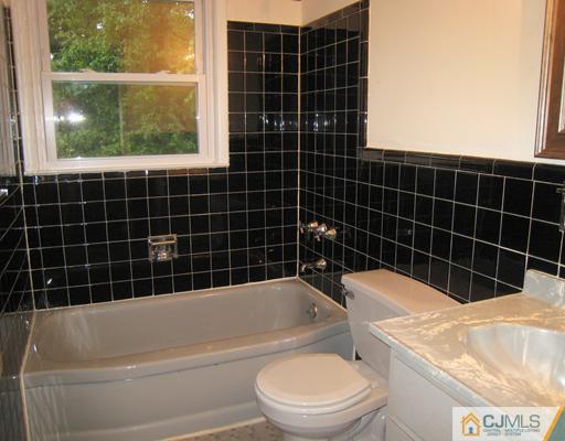 10 Gulf Road East Brunswick, NJ 08816 - Photo 11 of 25 a bathroom with a bathtub toilet and window