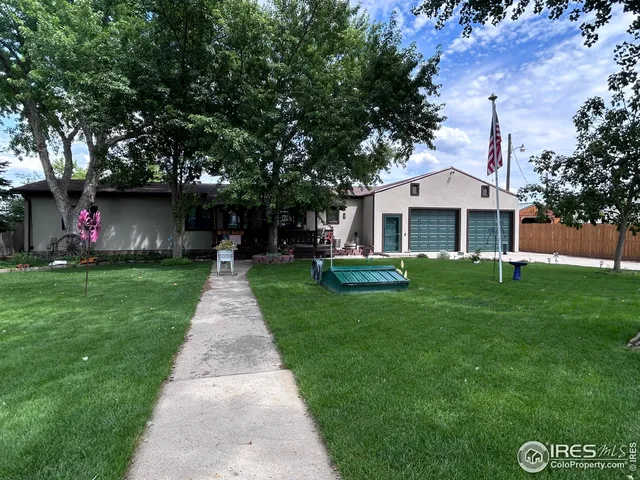 a front view of a house with a garden and yard
