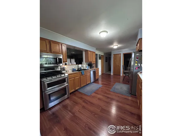 a kitchen with stainless steel appliances kitchen island granite countertop a stove and a refrigerator