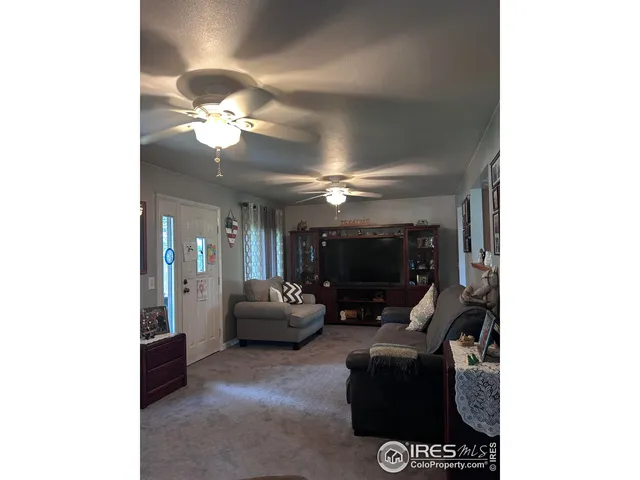 a living room with furniture and a ceiling fan