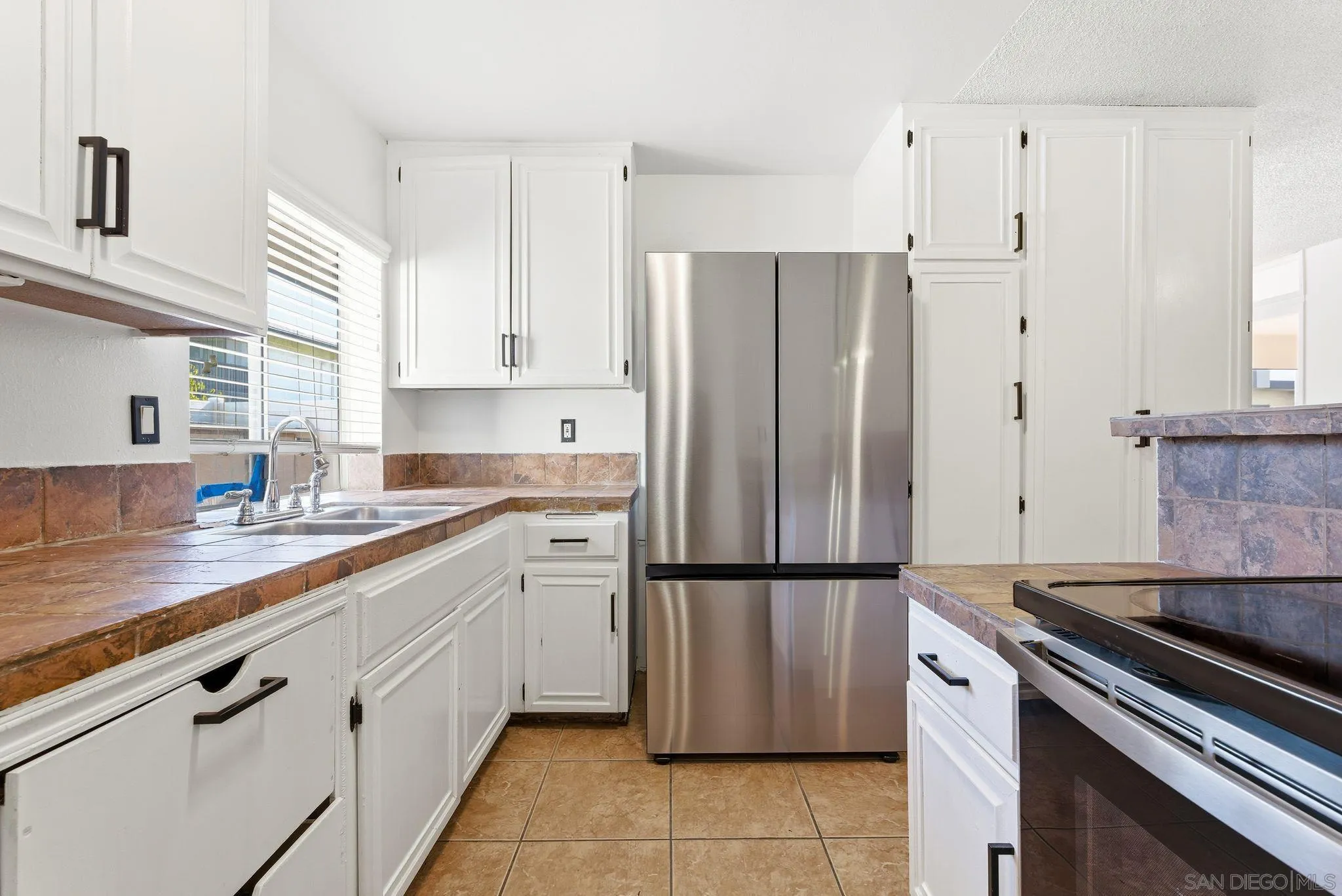 262 Rancho Drive, Unit C Chula Vista, CA 91911 - Photo 8 of 29 a kitchen with a refrigerator sink and cabinets