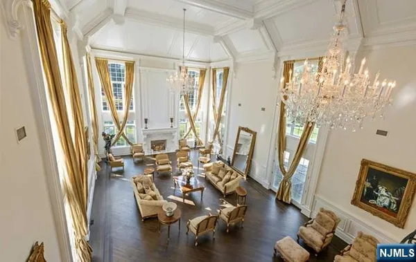 a living room with couches bookshelf and a large window