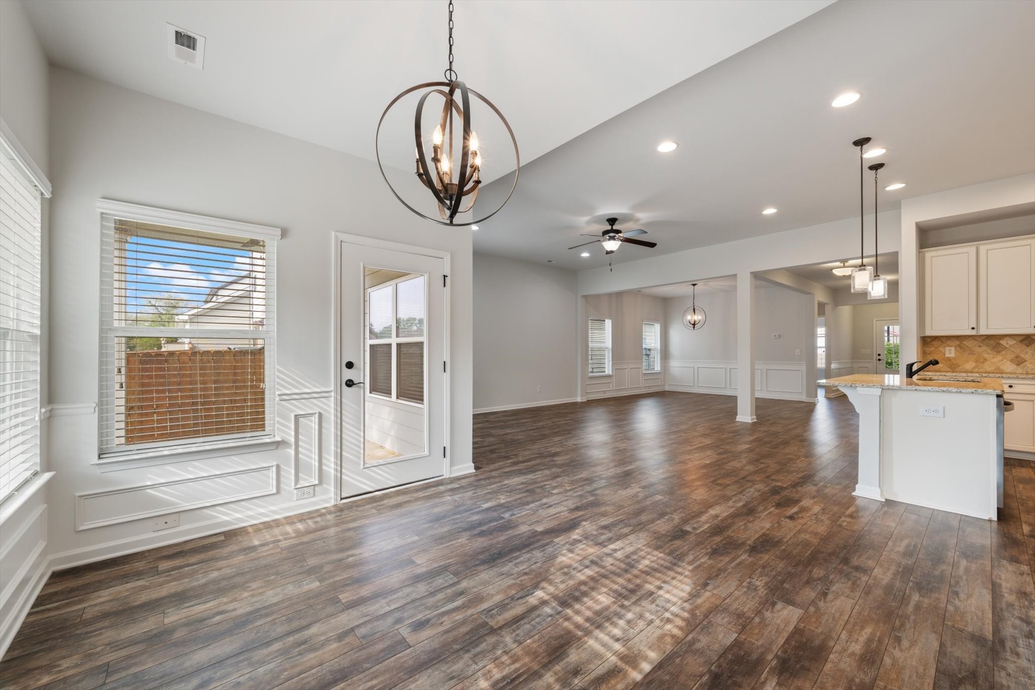 920 Carnation Drive Spring Hill, TN 37174 - Photo 14 of 27 a view of an empty room and kitchen with wooden floor and fan