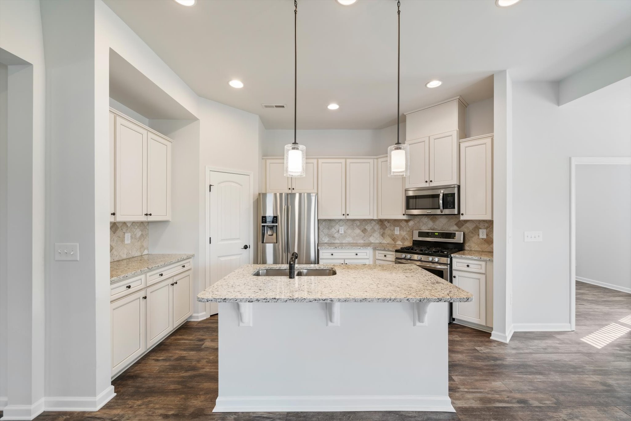 920 Carnation Drive Spring Hill, TN 37174 - Photo 6 of 27 a kitchen with kitchen island granite countertop a stove a sink a center island and cabinets