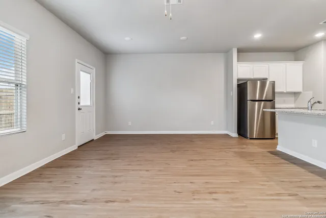 a view of empty room with wooden floor