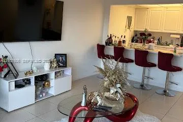 a living room with furniture kitchen view and a large window