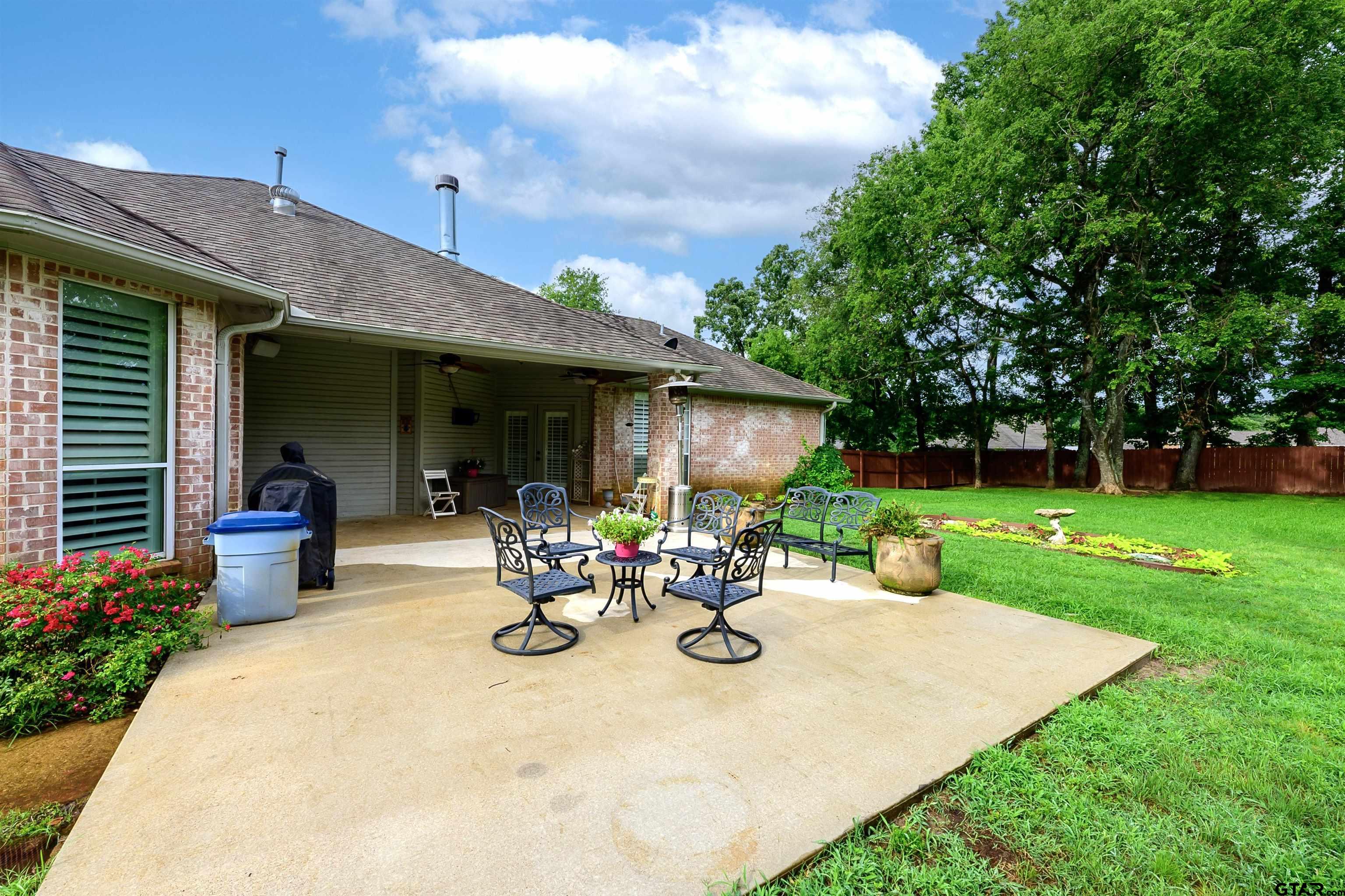 10074 Hillside Lane Flint, TX 75762 - Photo 20 of 22 a view of a patio with a table and chairs under an umbrella