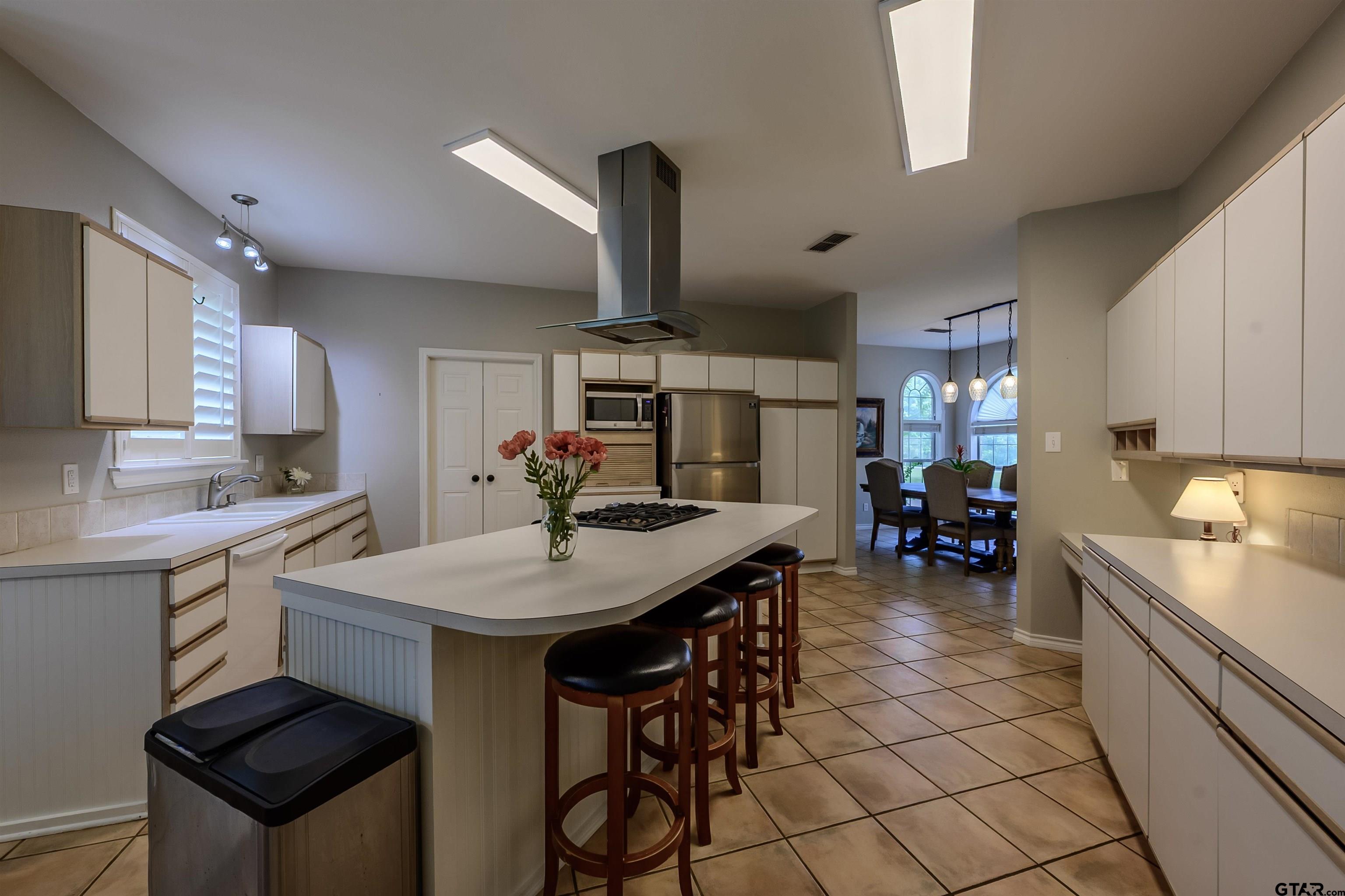 10074 Hillside Lane Flint, TX 75762 - Photo 8 of 22 a kitchen with stainless steel appliances kitchen island granite countertop a sink a stove and chairs