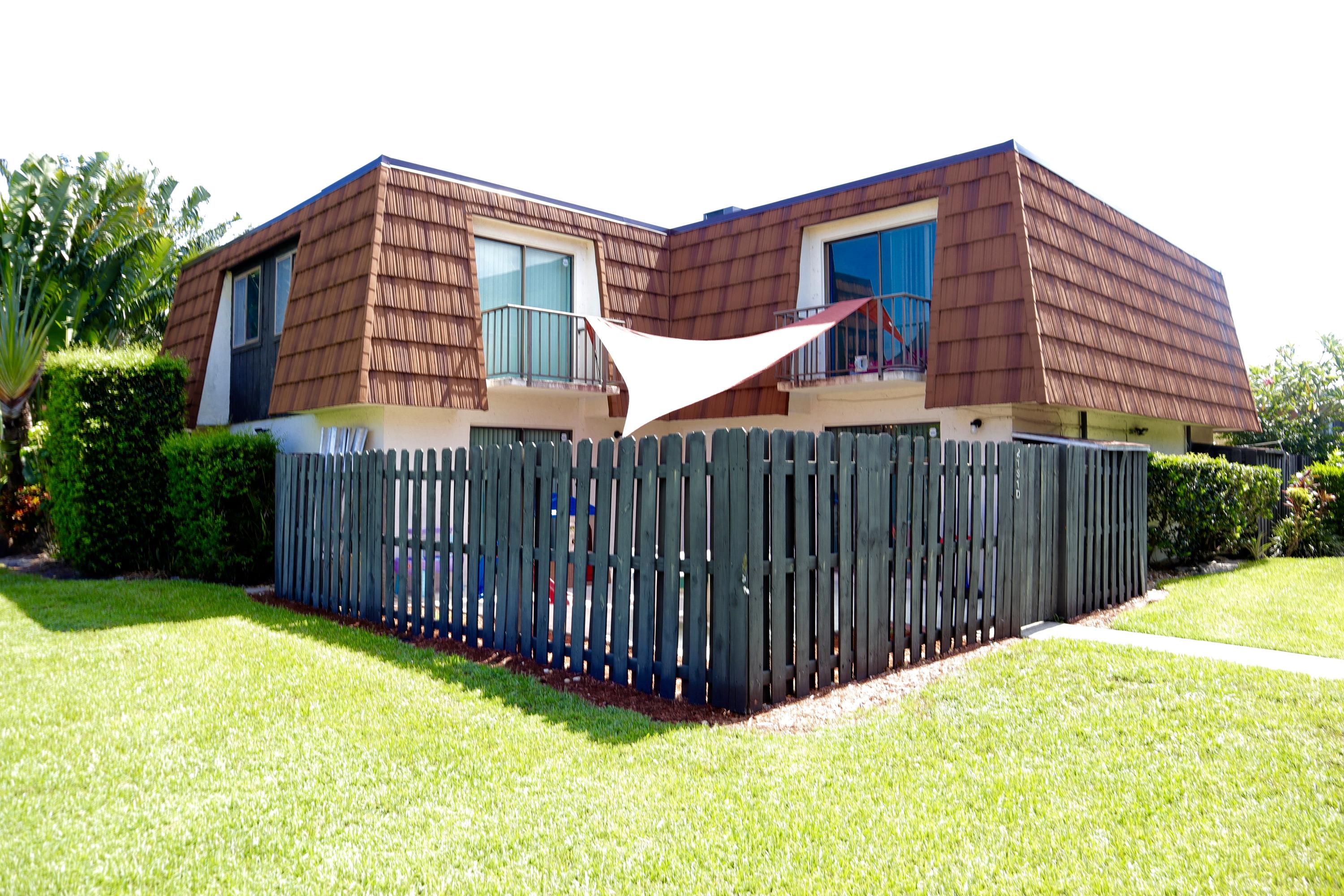 a view of a house with wooden fence