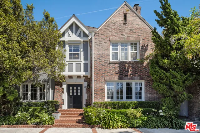 front view of a brick house with a yard
