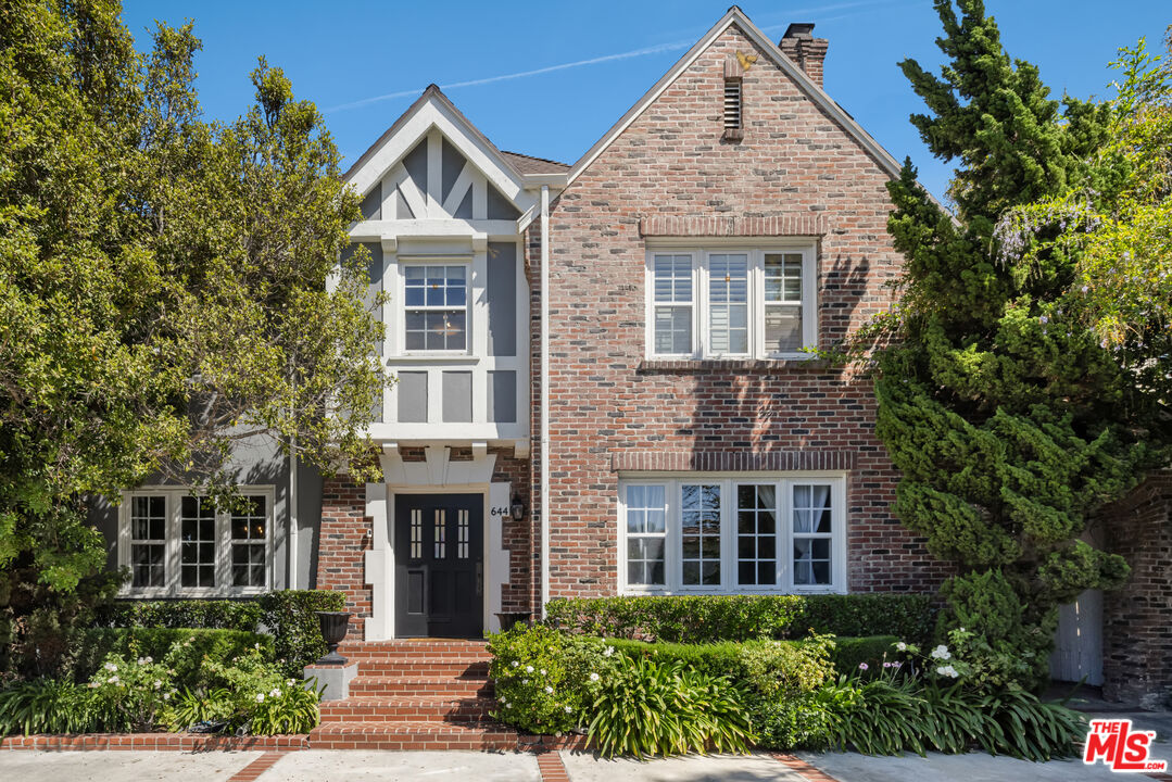 front view of a brick house with a yard