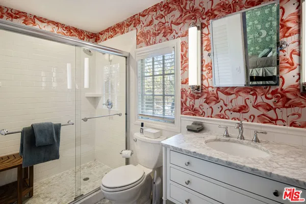 a bathroom with a granite countertop sink a toilet and shower