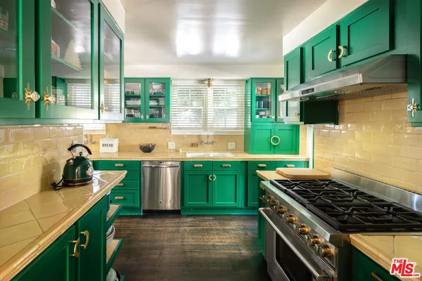 a kitchen with kitchen island a sink stove and cabinets