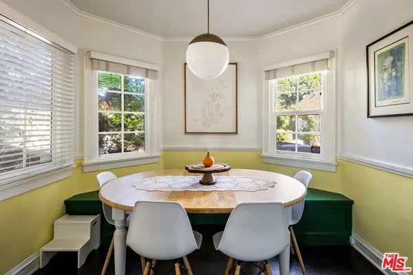a dining room with furniture a window and wooden floor