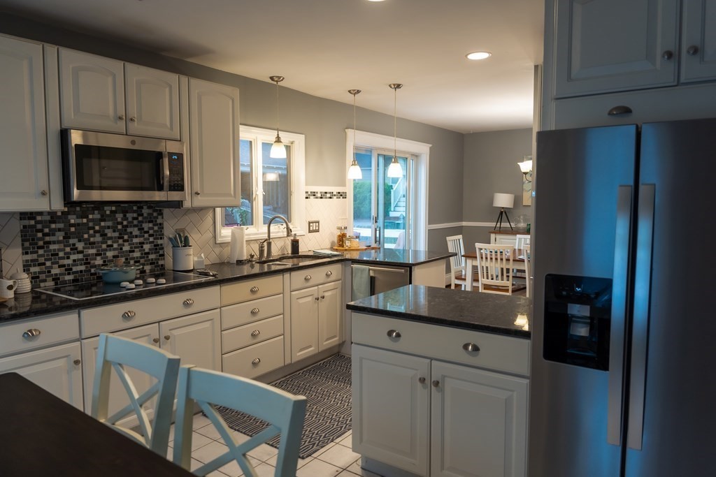12 Newcastle Road Peabody, MA 01960 - Photo 6 of 35 a kitchen with granite countertop white cabinets sink and stainless steel appliances