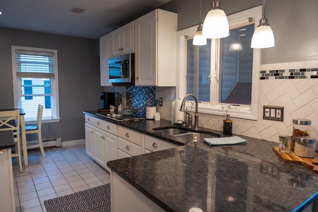 12 Newcastle Road Peabody, MA 01960 - Photo 10 of 35 a kitchen with stainless steel appliances granite countertop a sink and a stove