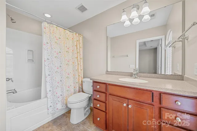 a bathroom with a granite countertop sink a toilet a mirror and shower