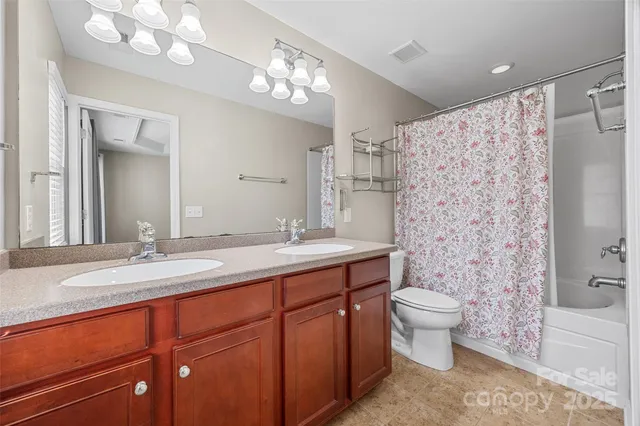 a spacious bathroom with a double vanity sink mirror and toilet