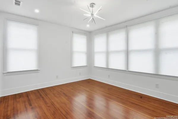 a view of an empty room with wooden floor