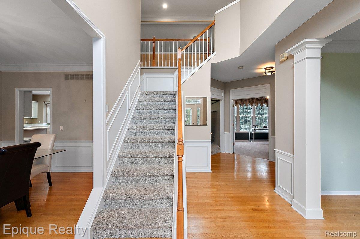 1909 Catlin Drive Rochester, MI 48306 - Photo 11 of 76 Grand foyer with wood-finish flooring, a carpeted staircase with wood handrails, decorative wainscoting, and recessed lighting