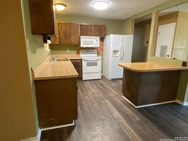 a kitchen with a sink a refrigerator a washer and dryer