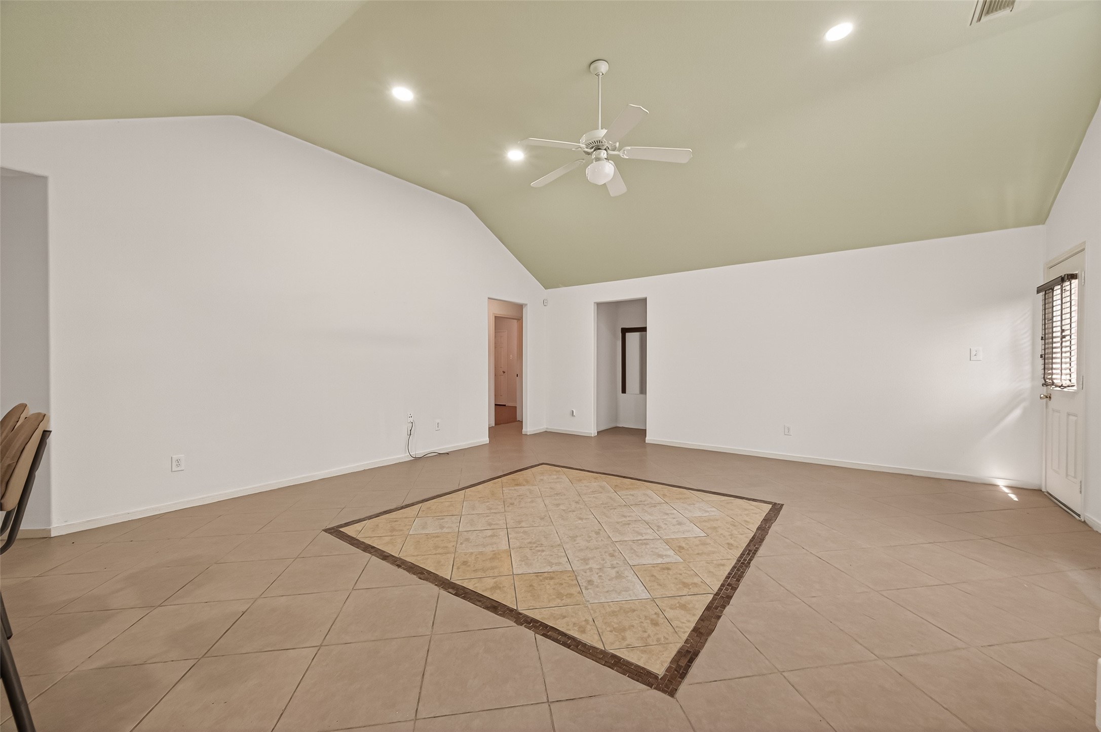 19322 Dawn Canyon Road Houston, TX 77084 - Photo 5 of 37 This spacious living area features a high ceiling with recessed lighting and a ceiling fan. The room has neutral tile flooring with a decorative central inlay.