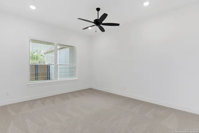 an empty room with a window and a fan