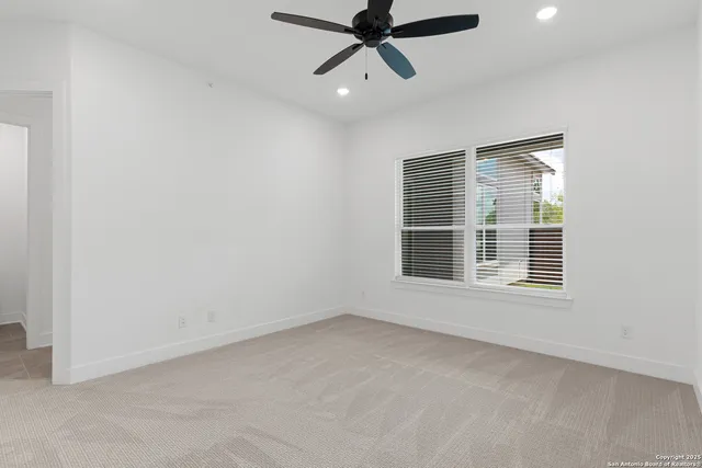 an empty room with closet and a chandelier fan