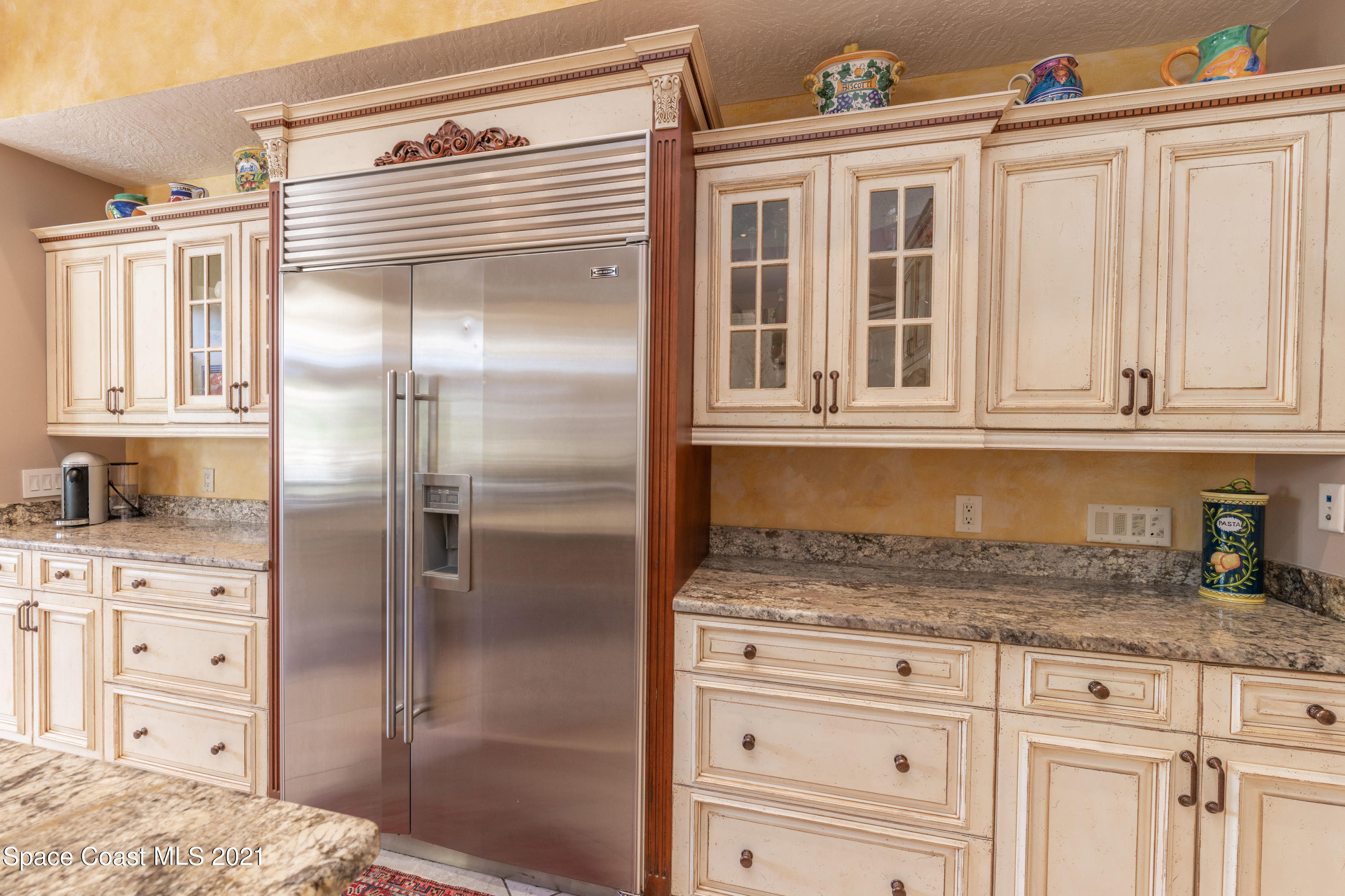 3835 Raney Road Titusville, FL 32780 - Photo 23 of 55 a kitchen with granite countertop a refrigerator and cabinets