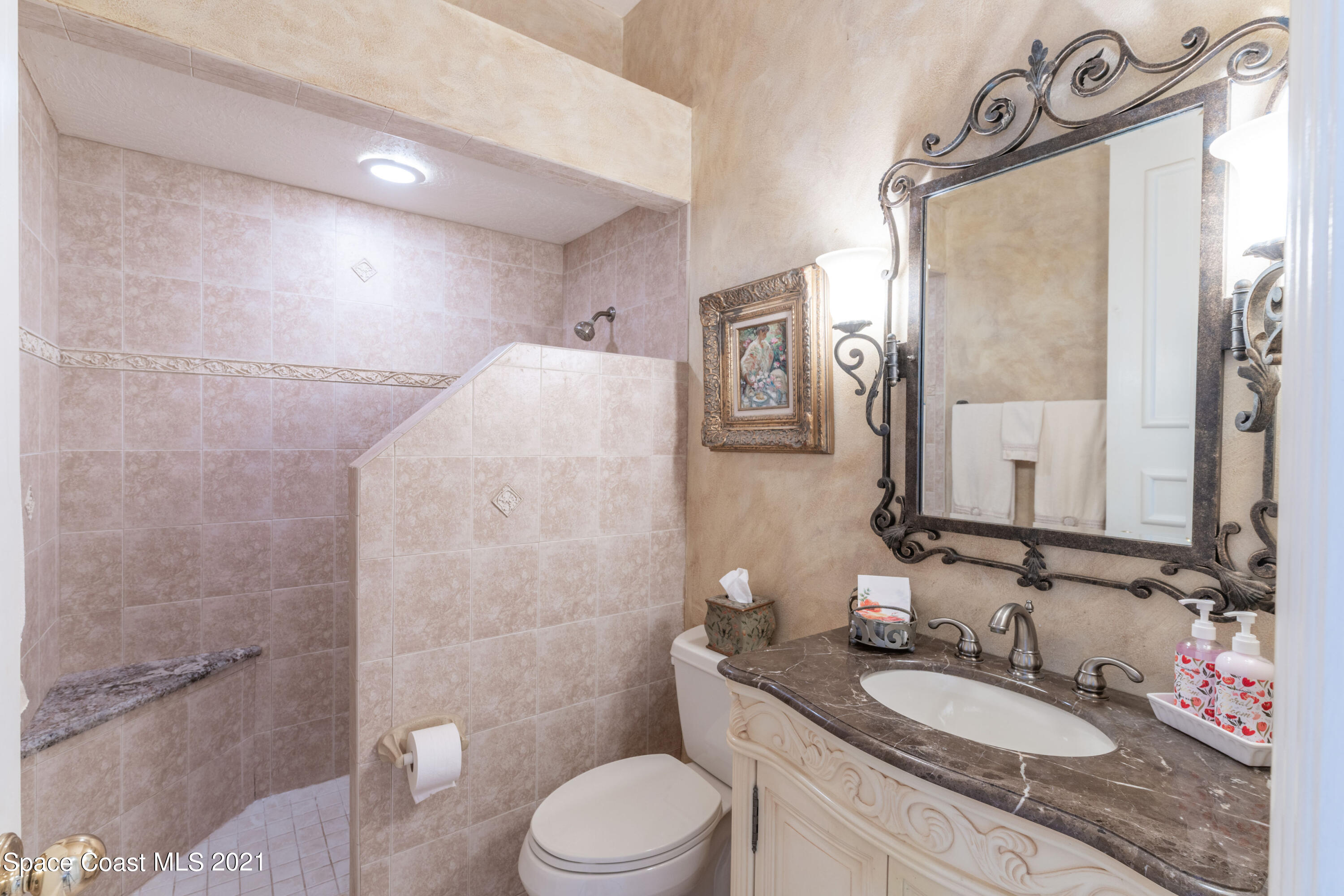 3835 Raney Road Titusville, FL 32780 - Photo 39 of 55 a bathroom with a granite countertop sink toilet a mirror and shower