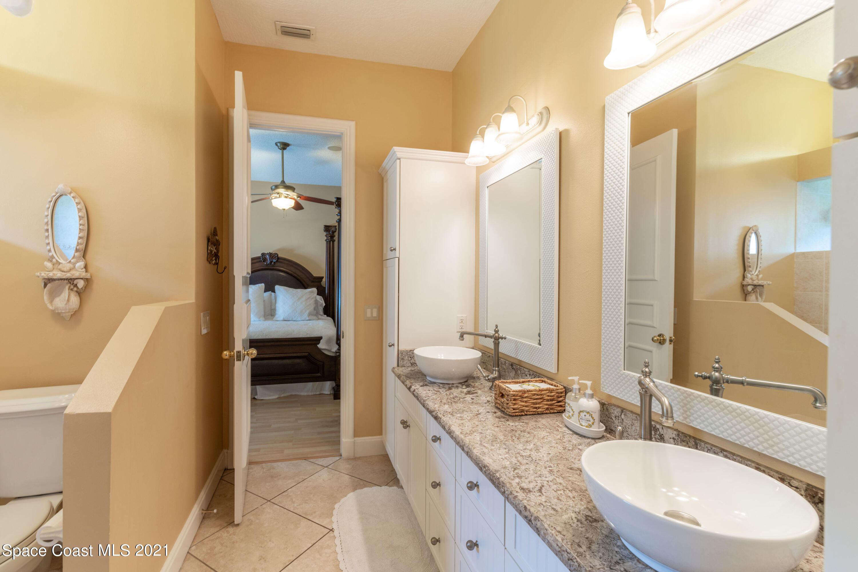 3835 Raney Road Titusville, FL 32780 - Photo 41 of 55 a en suite bathroom with a granite countertop sink and a mirror