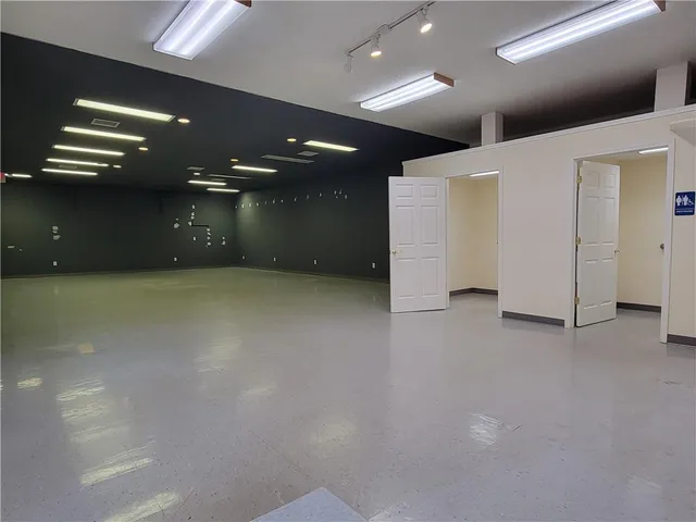 an empty room with a projector and windows