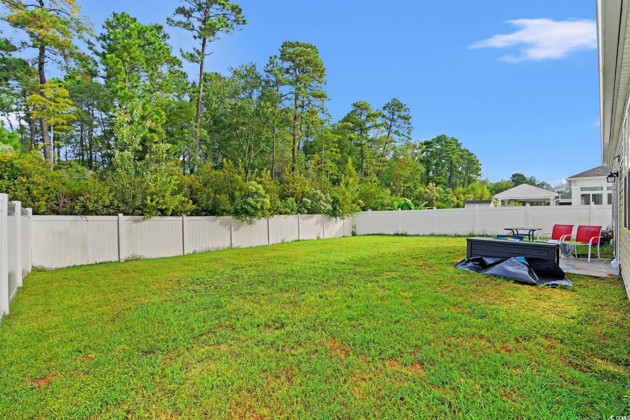 236 Legends Village Loop Myrtle Beach, SC 29579 - Photo 17 of 23 Fenced backyard featuring a patio area and view of wooded area
